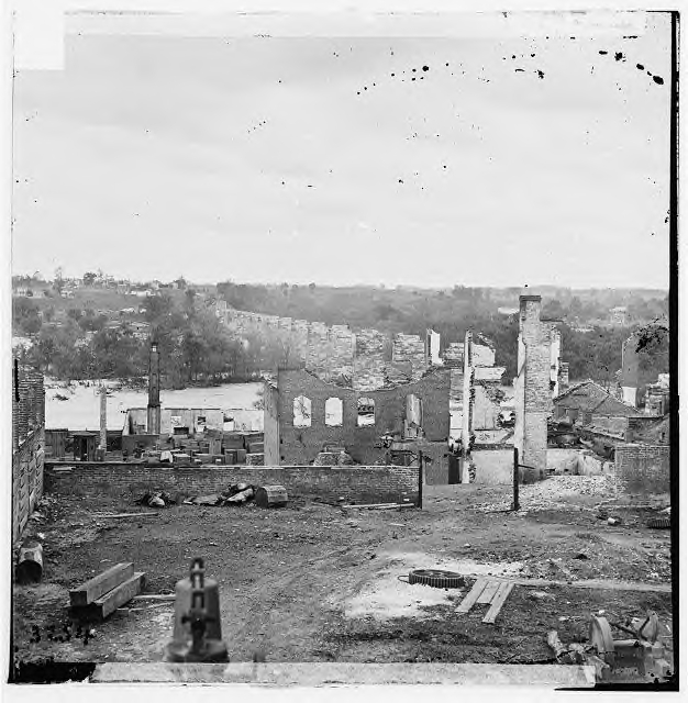 Ruins of the Richmond & Petersburg RR bridge into Richmond. The view is looking south, out of the city and over the James River. Since the stone piles had not been damaged (something very difficult to do), the repair of this bridge would not be particularly difficult.